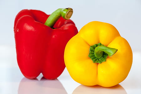 red and yellow peppers on white table