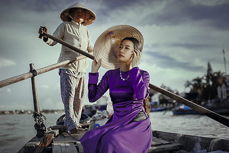 woman wearing purple silk long-sleeved dress on brown wooden boat