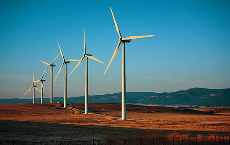six white wind mills on landscape field