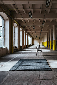 Interior of an abandoned building hall with yellow pillars