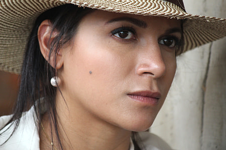 close-up photography of woman in beige sun hat