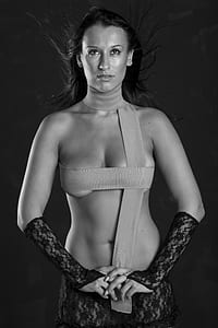 grayscale photo of covering her body with strap with lace hand warmer