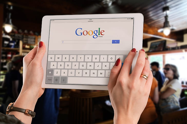 person using iPad searing in google search engine