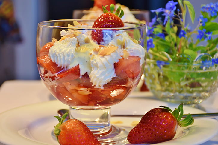 strawberries with cream on clear glass cup