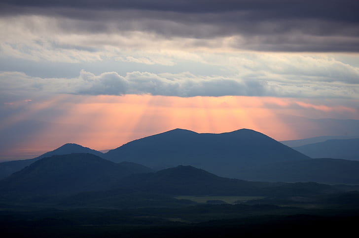 silhouette of mountain with ray of lights
