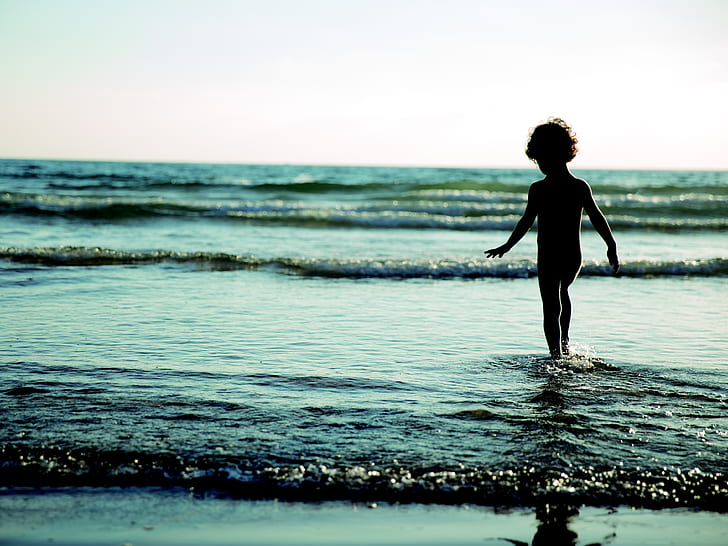 toddler walking on body of water