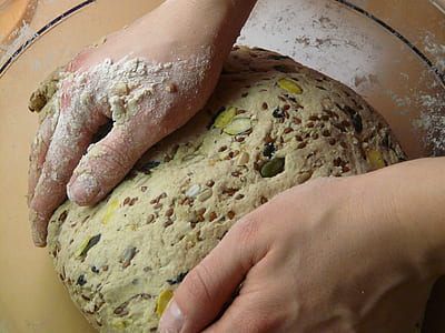 person kneading dough with beans