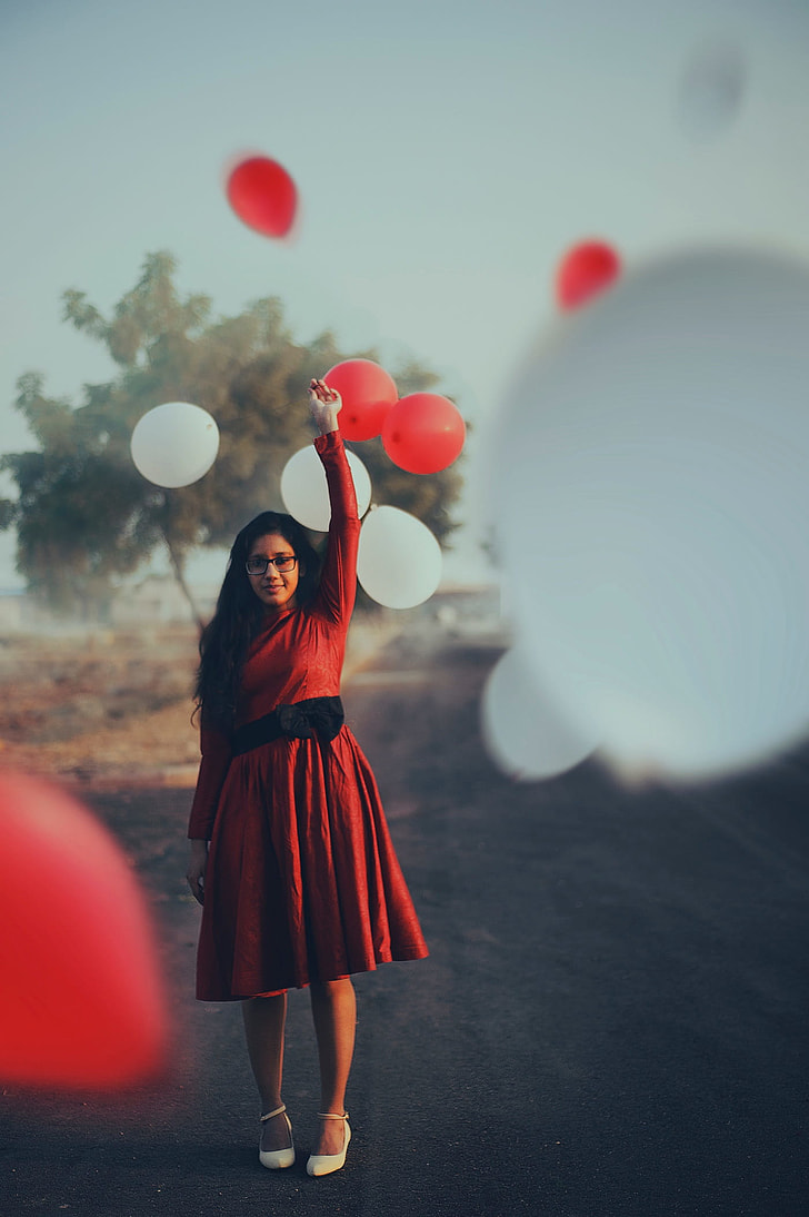 woman in red long-sleeved midi dress holding balloon during daytime