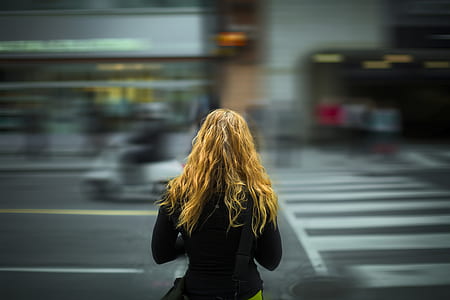 timelapse photography of woman walking at the pedestrian lane