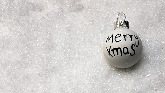 Merry Xmas printed bauble on silver surface