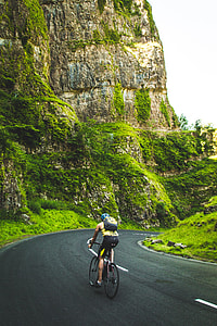 man riding on bike near brown rock formation