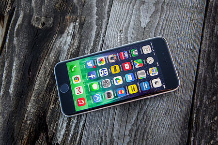 High resolution shot of the iPhone 6 mobile smartphone on a wood textured background