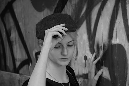 Woman Holding Her Cap in Grayscale