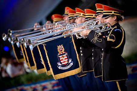 People in Uniform Using a Trumpet Instrument With Blue and Yellow Flag Under