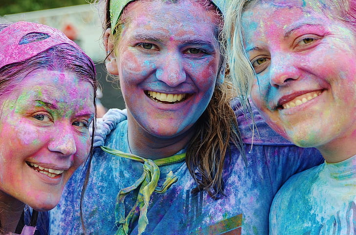 three women with assorted-color on their faces