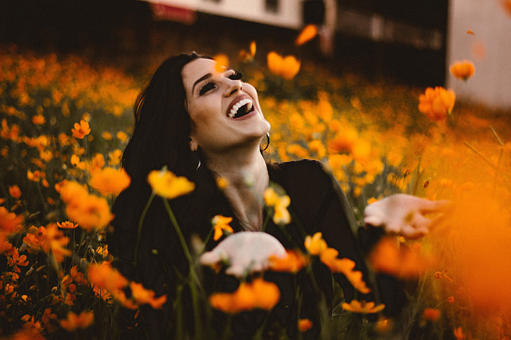 Laughing woman in flowers with smile