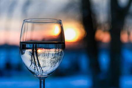 selective focus photography of clear wine glass during golden hour