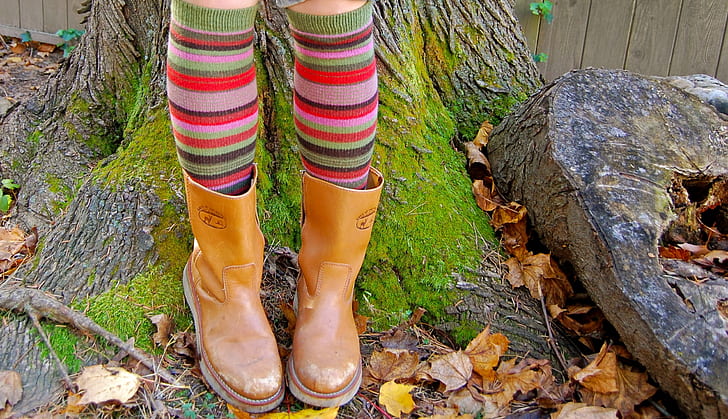 person wearing brown leather cowboy boots standing near brown tree during daytime