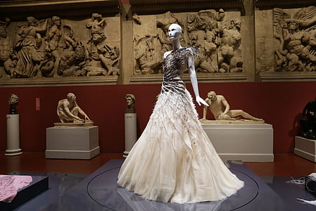white dress worn on mannequin display in front of the museum