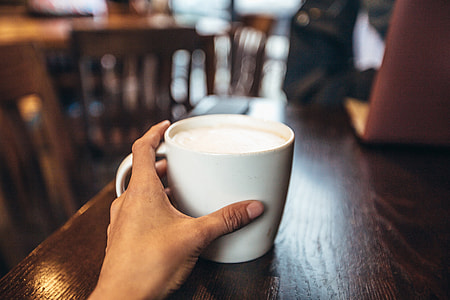Cafe coffee cup being held in a hand
