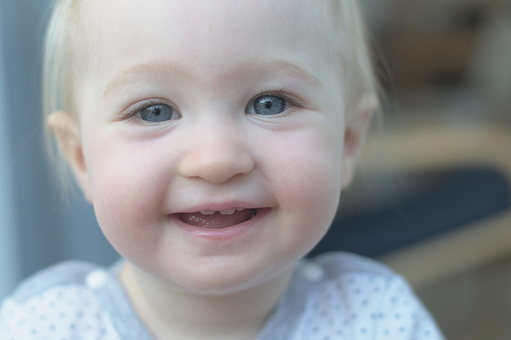 shallow focus photography of a toddler wearing white top