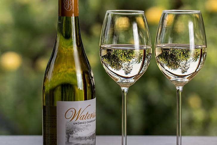 two wine glasses beside wine bottle