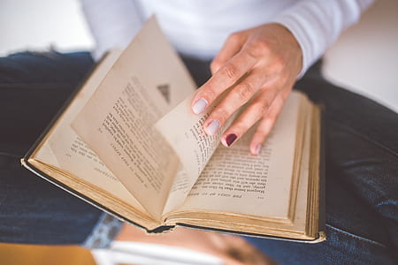 shallow focus photography of person holding book