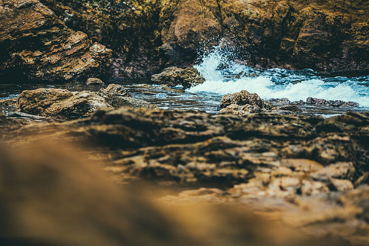 brown rock between water