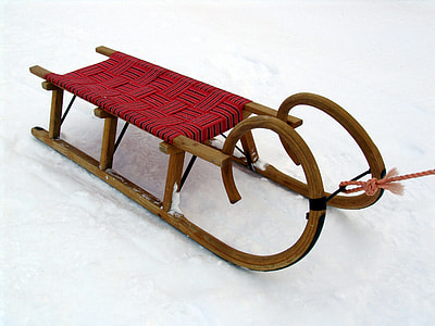 brown and red sled on snow