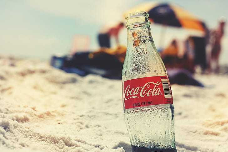 Coca-Cola glass bottle on seashore