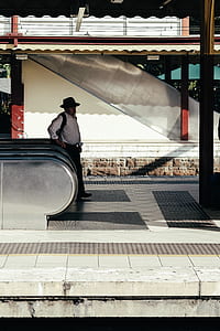 man standing beside escalator