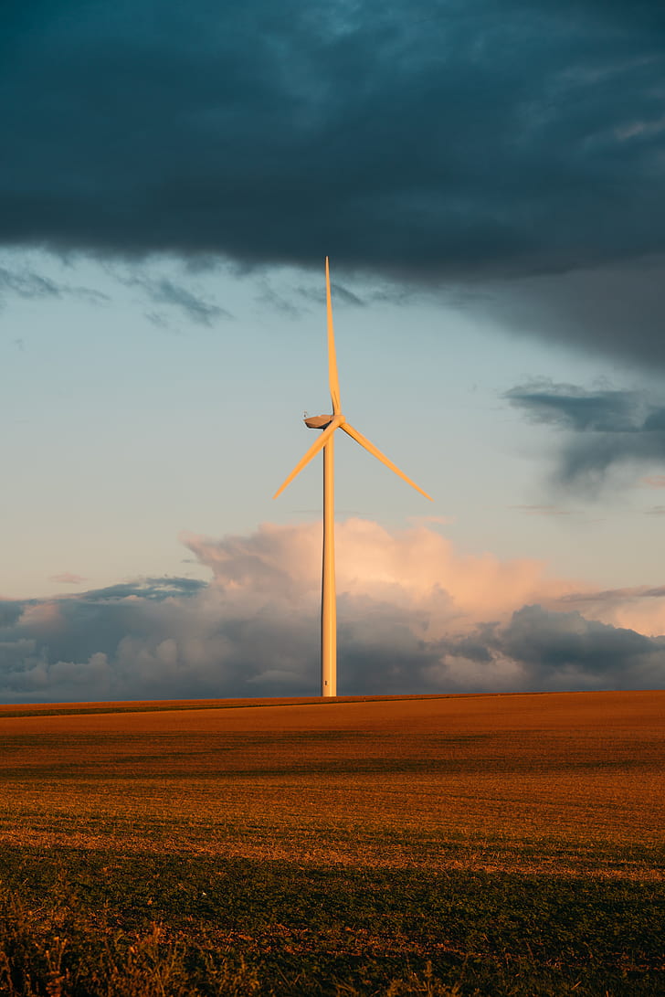 white wind turbine on the brown grass field