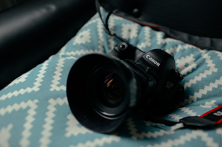 black Canon bridge camera on teal textile