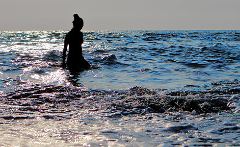 silhouette photography of woman in body of water
