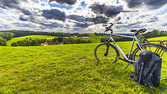 white hardtail bike on green grass under white clouds at daytime