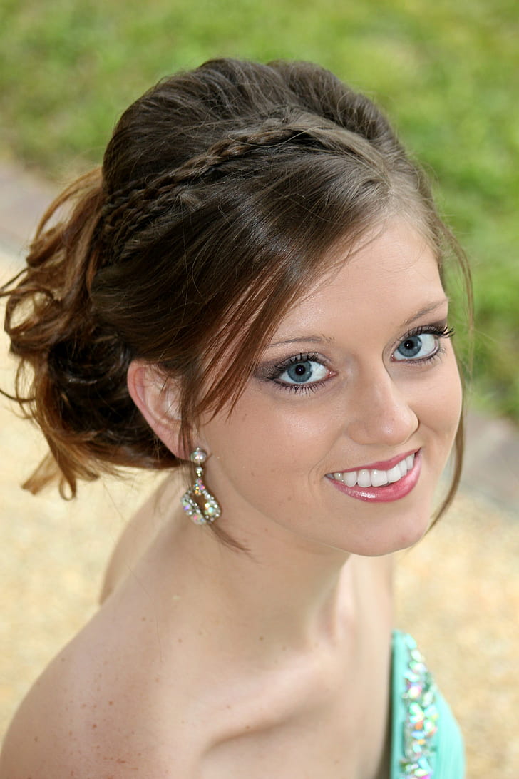 woman wearing teal sweetheart neckline dress smiling while taking photo