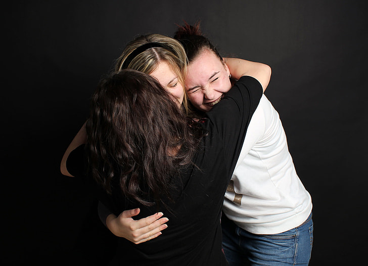 three woman hugging each other