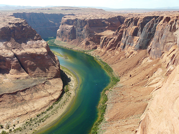 brown canyon between a river during daytime