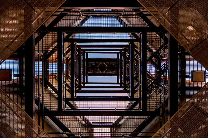 low angle photography of black and brown metal scaffolding frames during daytime
