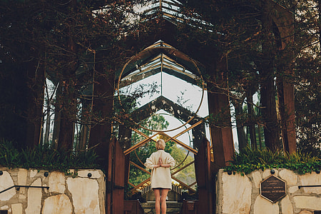 woman standing in front of wooden arch