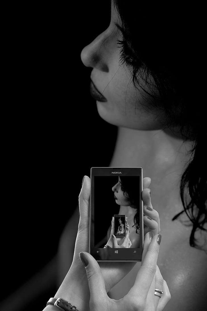 grayscale photo of woman in Nokia Windows smartphone