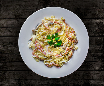pasta on round plate on brown wooden table