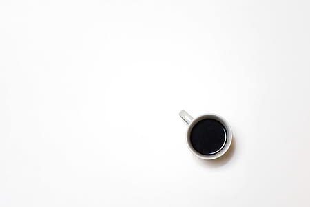 top view photo of white ceramic mug with tea on white surface