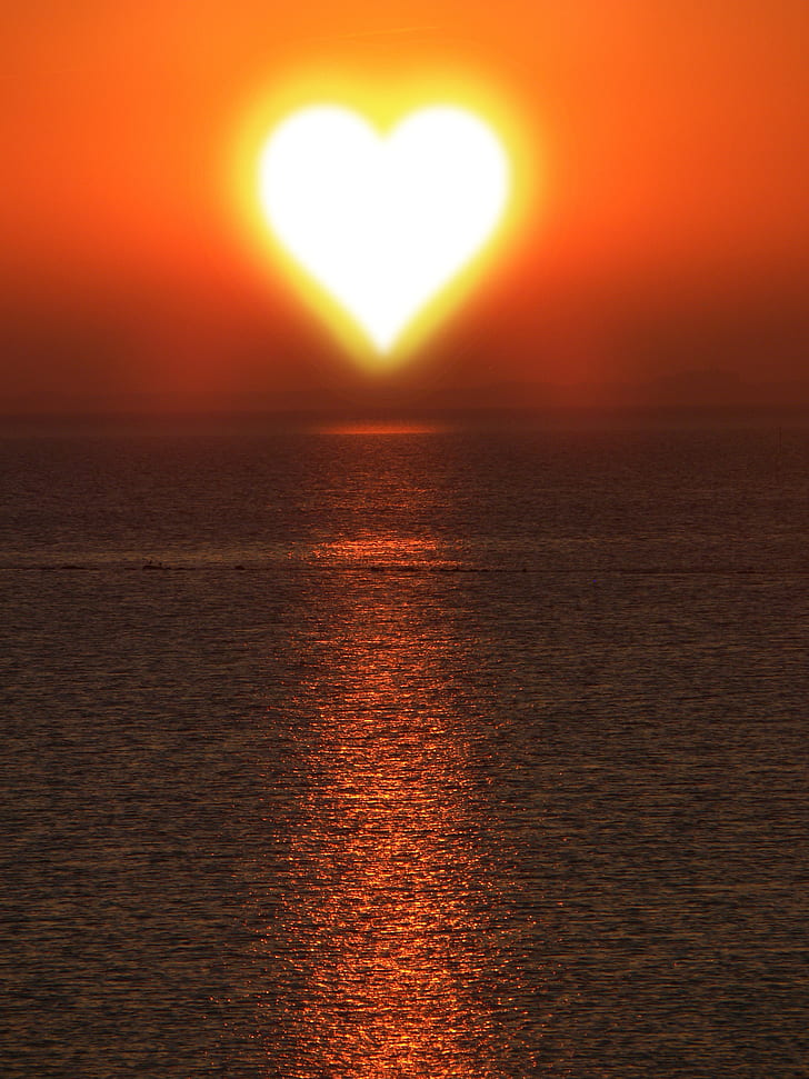 heart-shaped sun over body or water