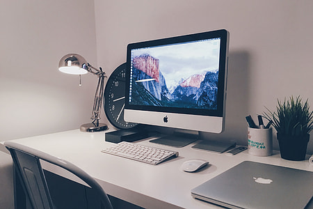 iMac computer and laptop on white office desk table