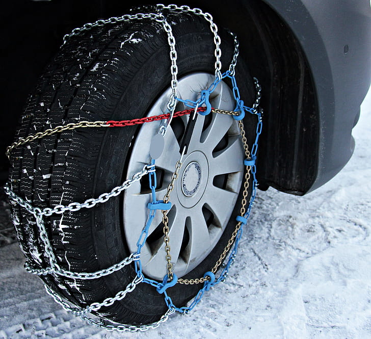 gray vehicle wheel with tire and chains