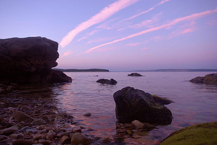 Rock Formation on Body of Water Under Altostratus Clouds