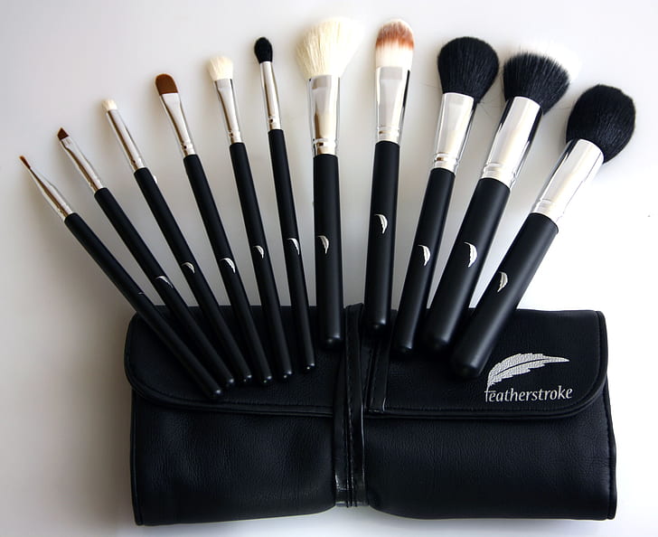 black-and-gray makeup brush set on white wooden board