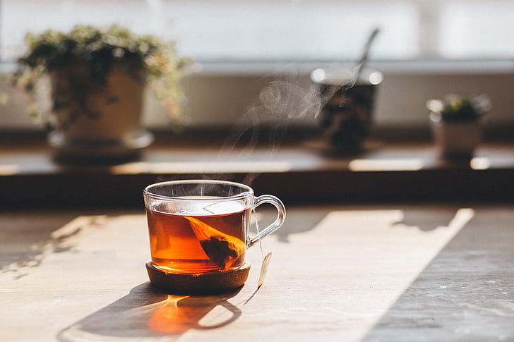 glass cup filled with tea during daytime