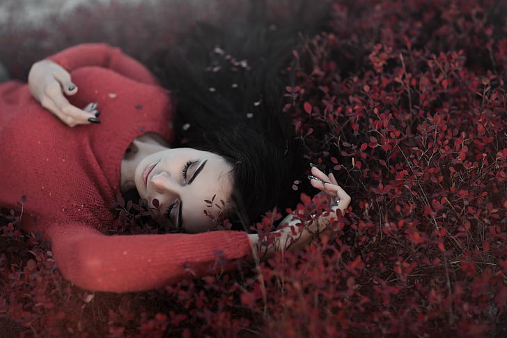 woman in red sweater lying in red flower field